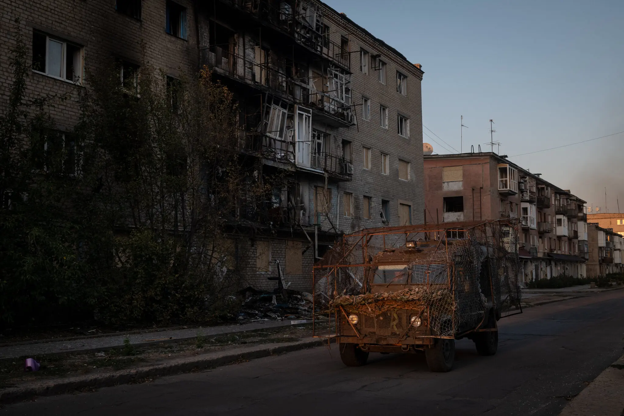Українська бронетехніка проїжджає повз пошкоджений житловий будинок у Кураховому.